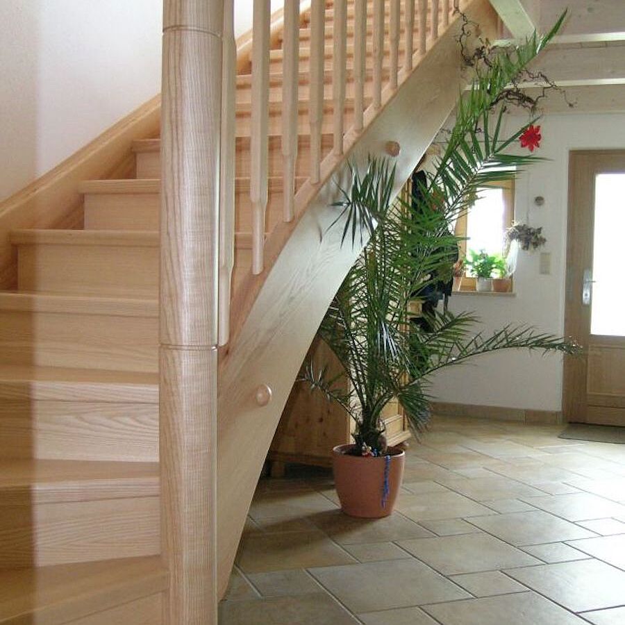 Viertelwendeltreppe mit rundem Antrittspfosten in Esche Viertelwendeltreppe mit rundem Antrittspfosten in Esche
